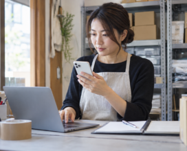 スマートフォンで届いた注文をパソコンで確認する店舗担当者