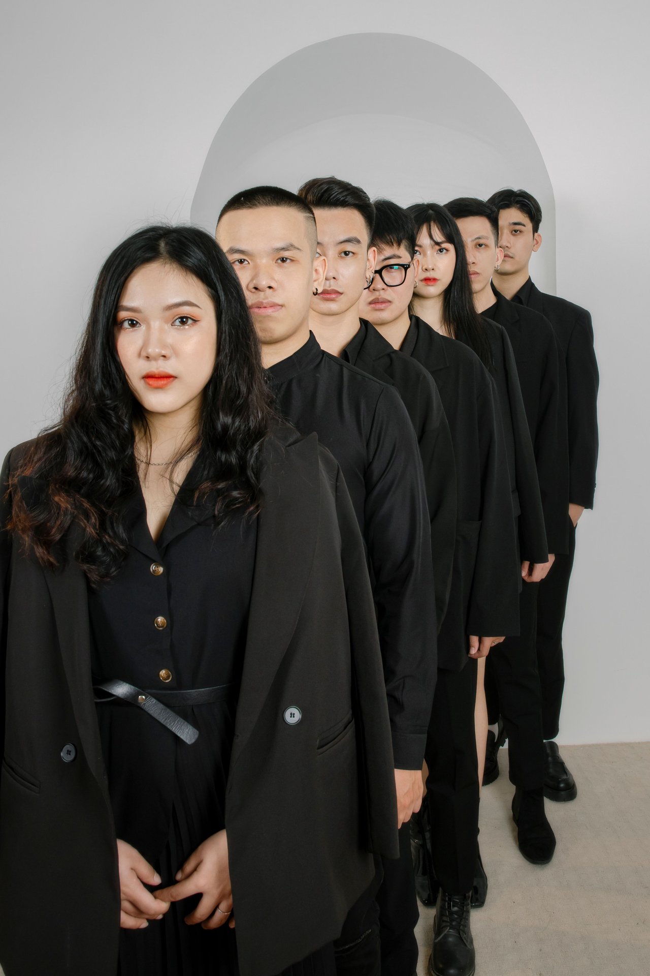 A group of well-dressed young adults in black outfits posing