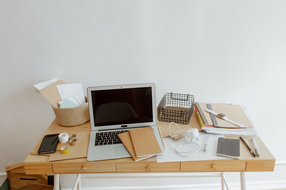 Clean and organized desk with a laptop, notebooks, and offic