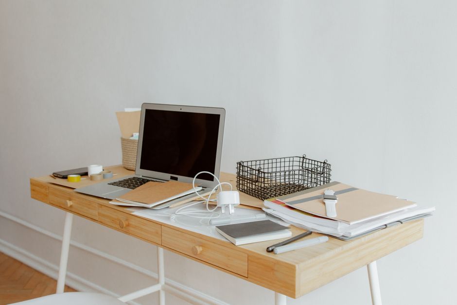 A neatly organized desk with a laptop, notebooks, and office