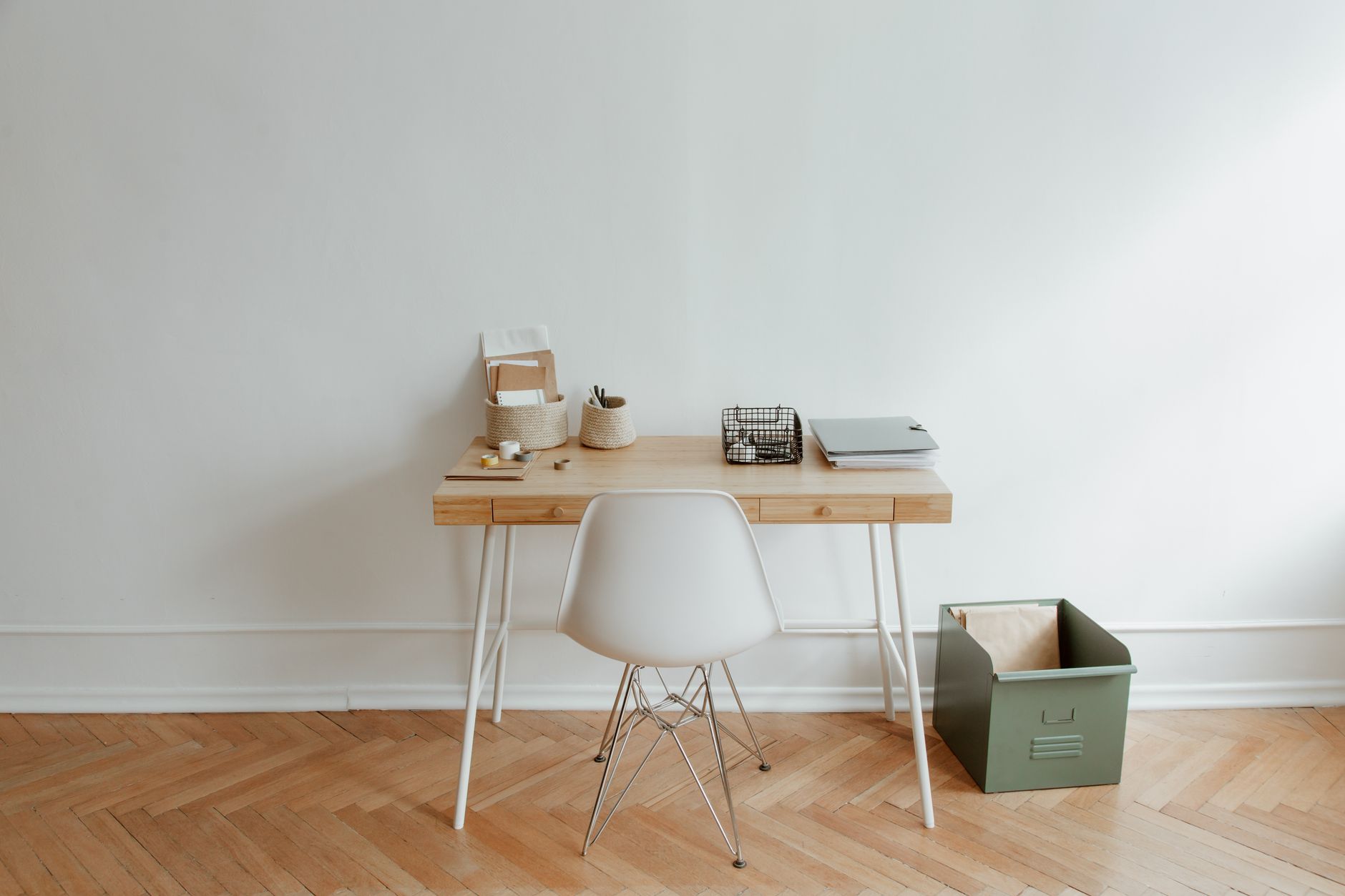 A minimalist home office setup with a wooden desk and a whit