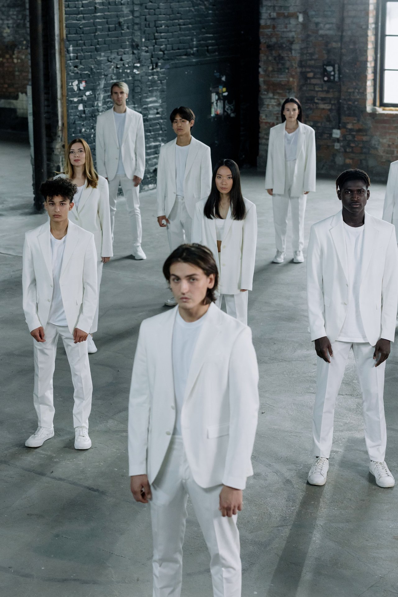 A diverse group of individuals in white clothing, standing i