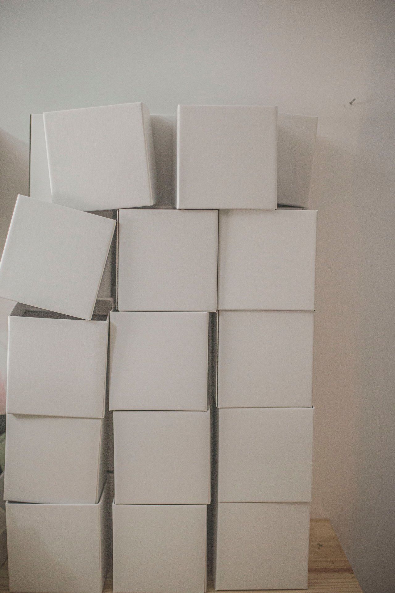 A vertical stack of plain white cardboard boxes creating a m