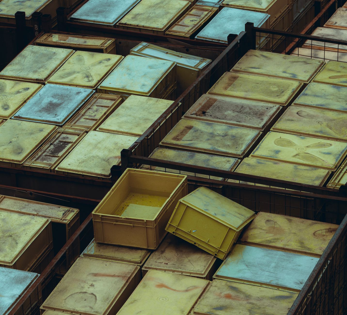 Overhead view of yellow and weathered plastic storage bins a