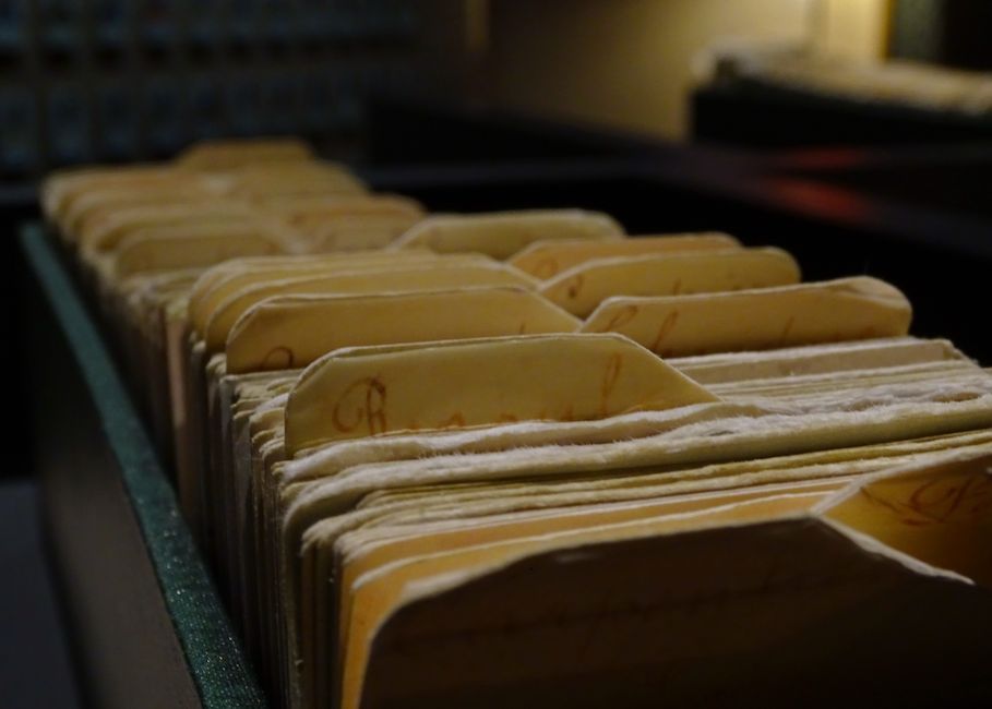 Vintage file folders organized in a row inside a dimly lit r
