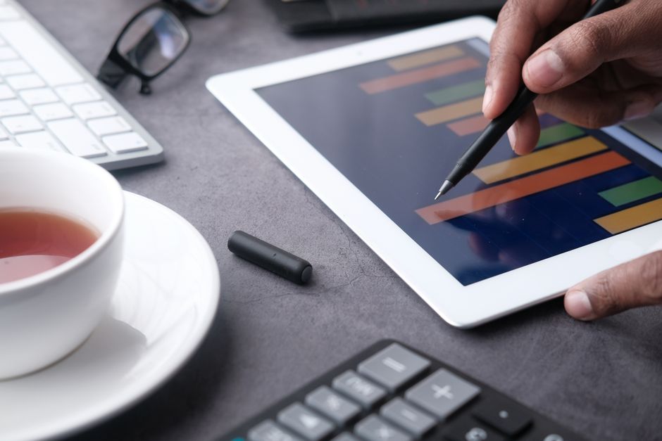 A close-up of a hand using a stylus on a tablet displaying b