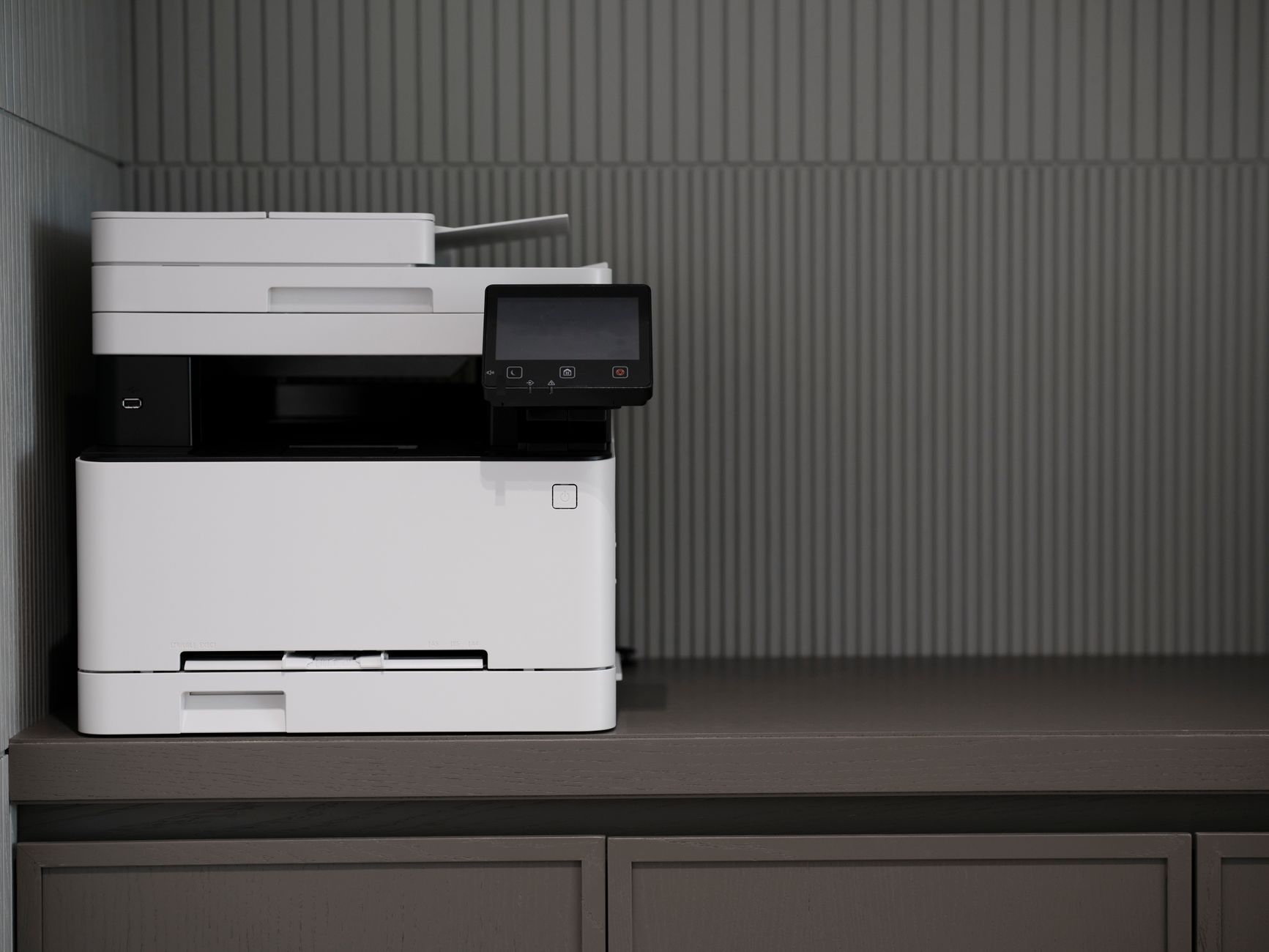 A sleek, modern printer situated on a minimalist office desk