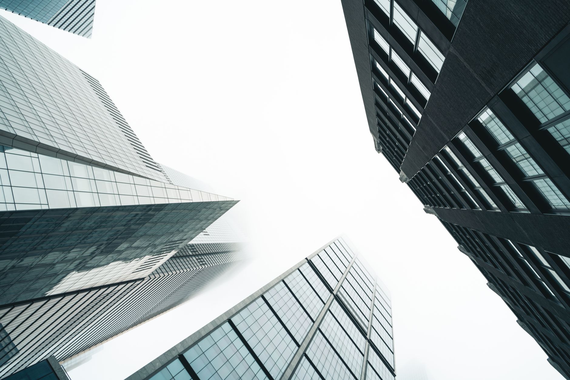 Low angle view of skyscrapers with glass facades against a b