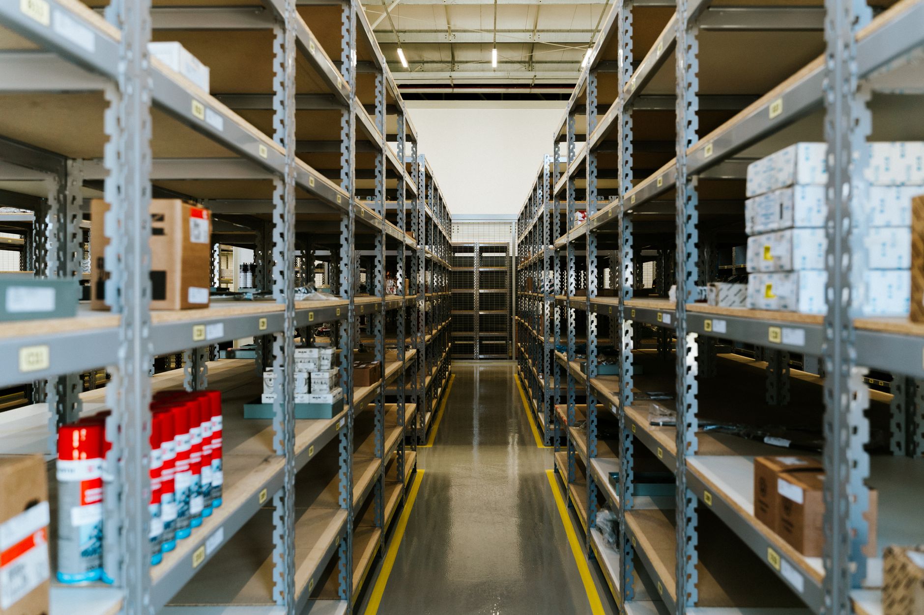 Wide view of an organized industrial warehouse with metal sh