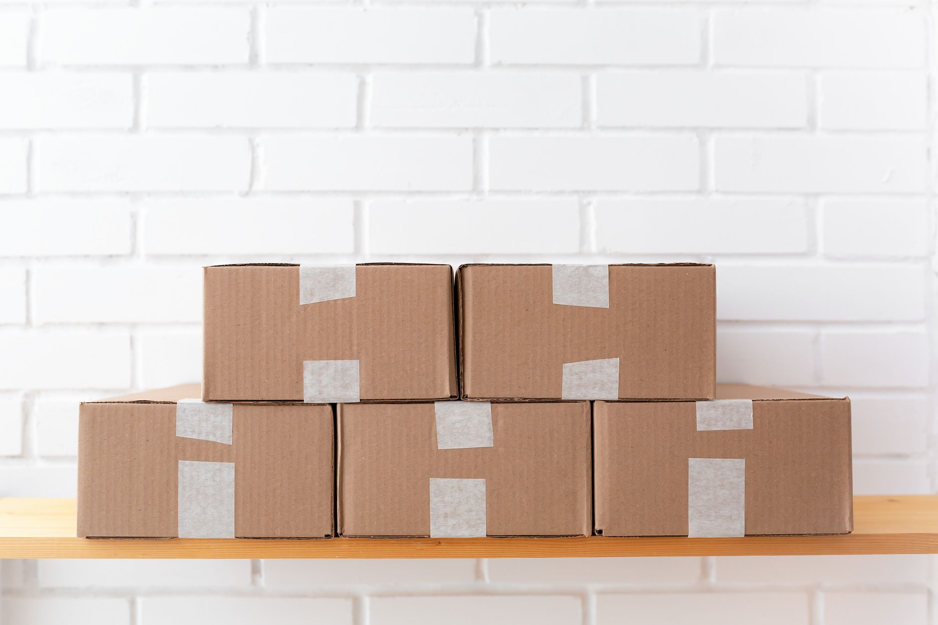 A neat stack of cardboard boxes taped and placed on a wooden