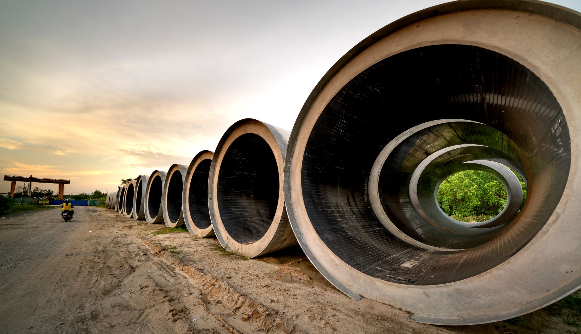 Massive concrete pipes aligned at a construction site during