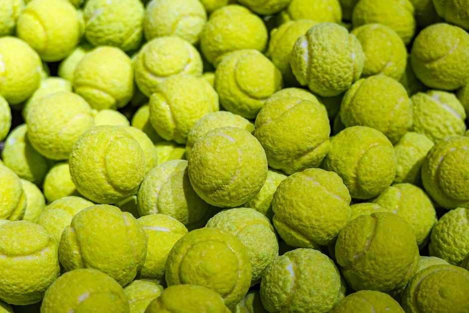 Close-up view of a large pile of bright yellow tennis balls.