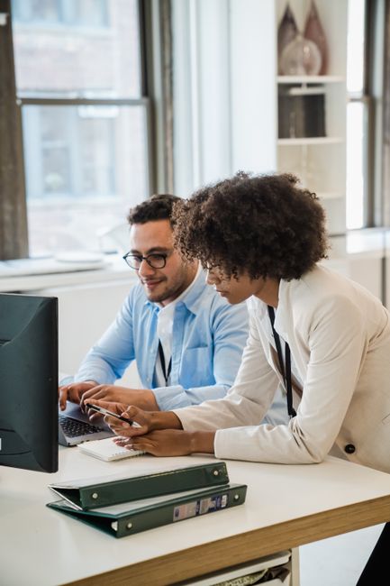 Two professionals collaborating at a desk in a modern office