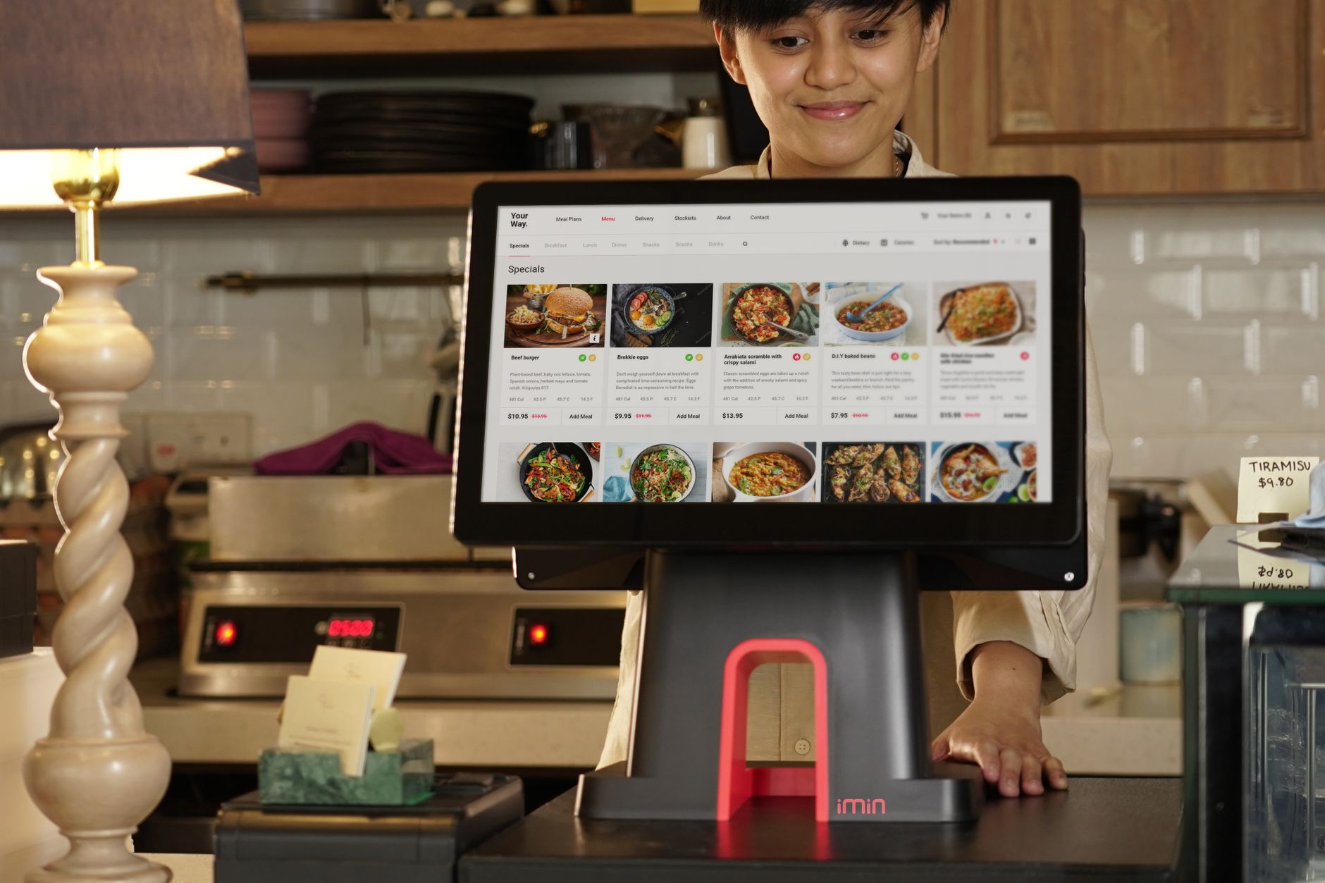 A cashier uses a touchscreen system for taking orders in a r