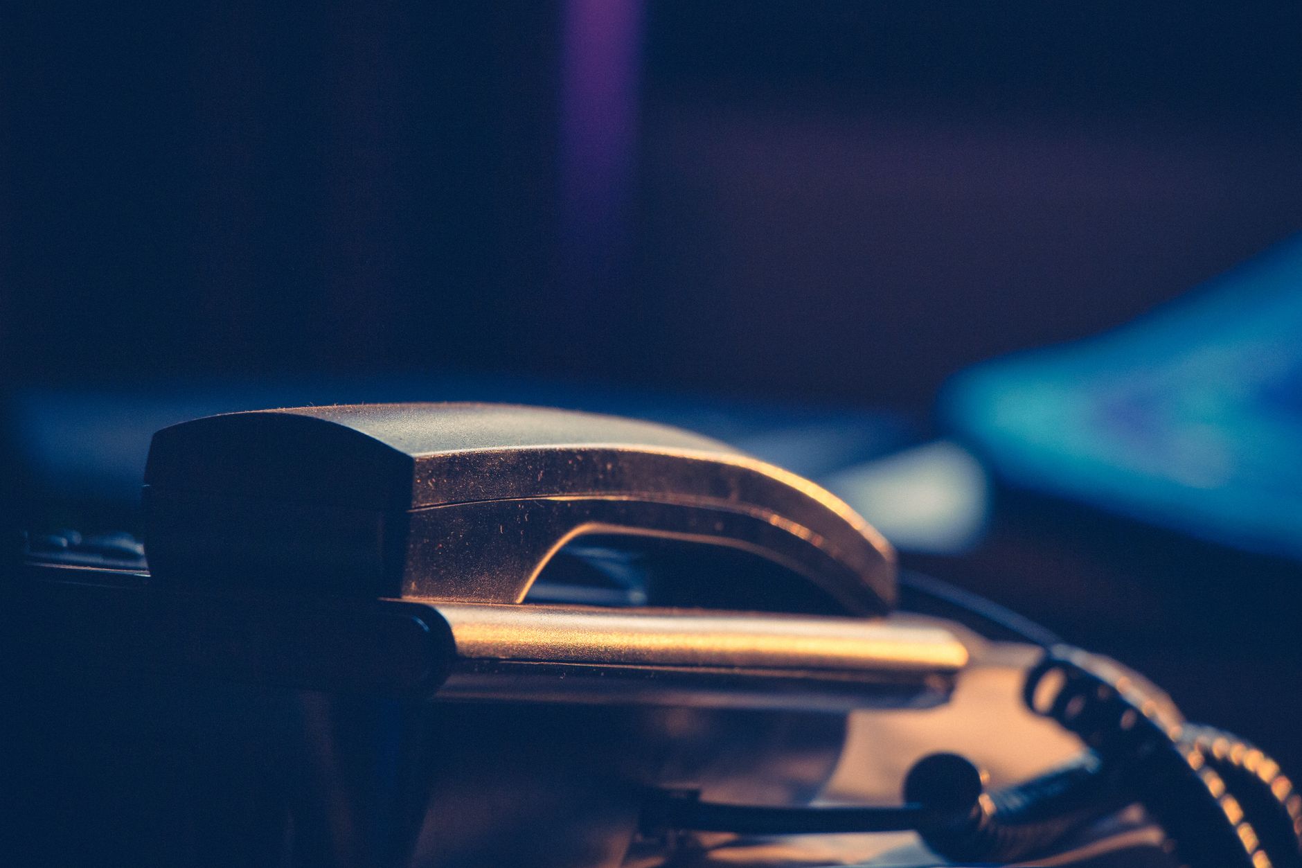A classic office telephone handset in a moody, dimly lit set