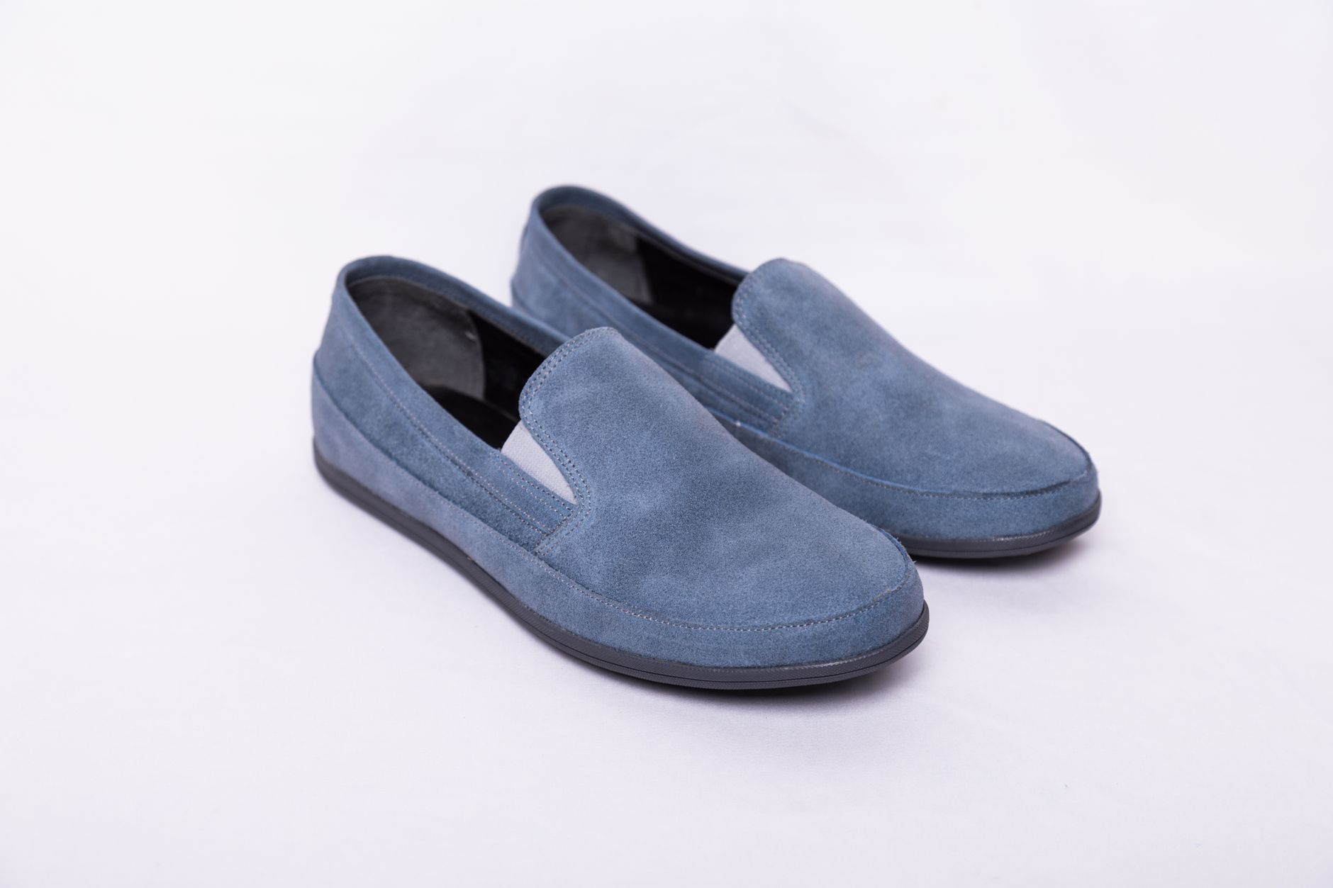 Beautiful close-up of stylish blue suede slip-on shoes with