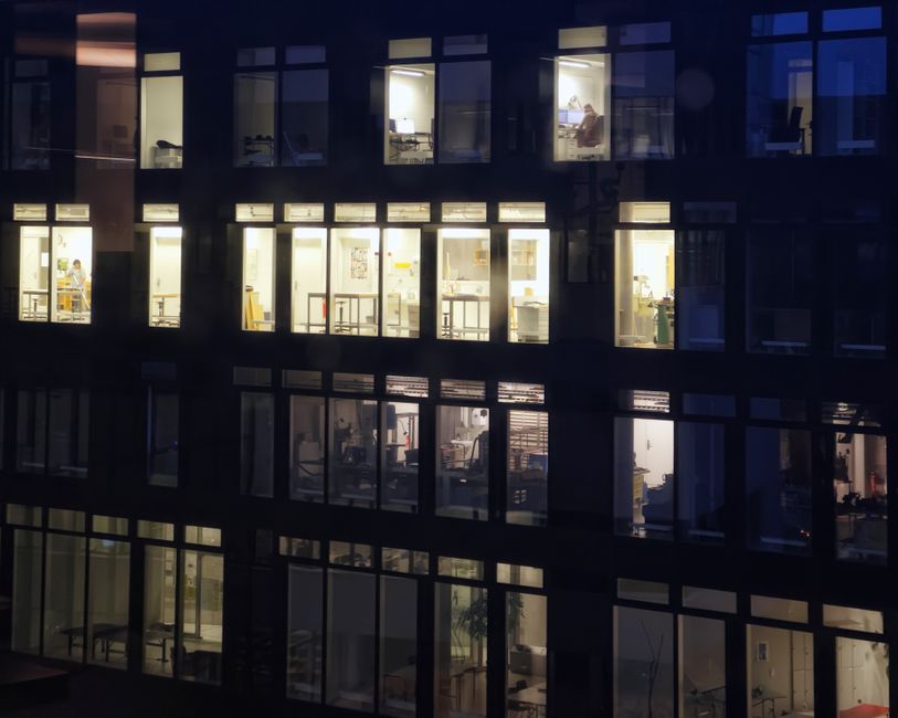 Office building exterior with lit windows at night, showing