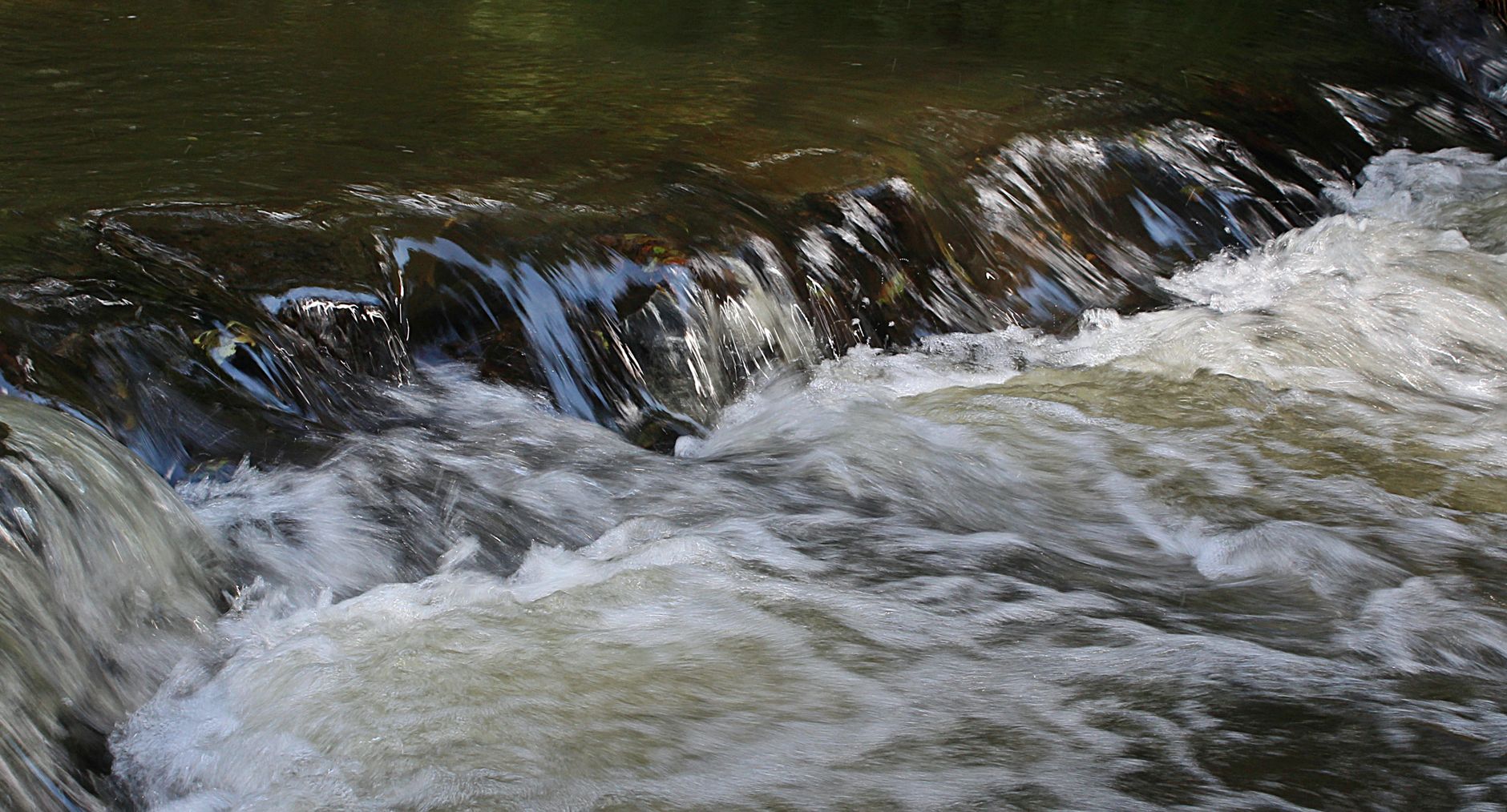 Captivating image of a rapid stream flowing over rocks, show