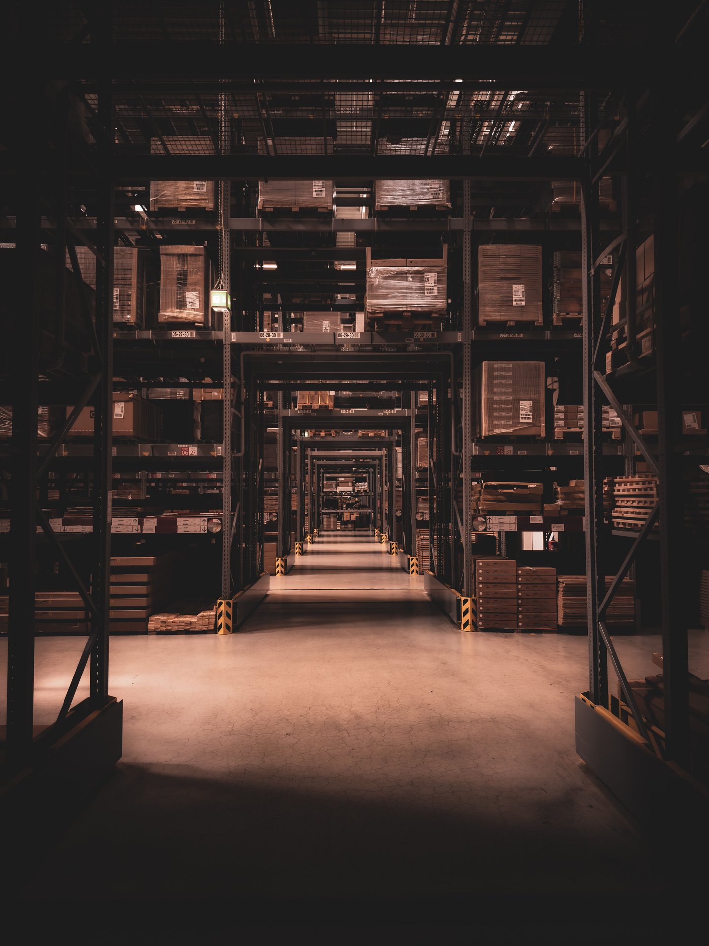 Dimly lit warehouse aisle in Berlin filled with large shelve