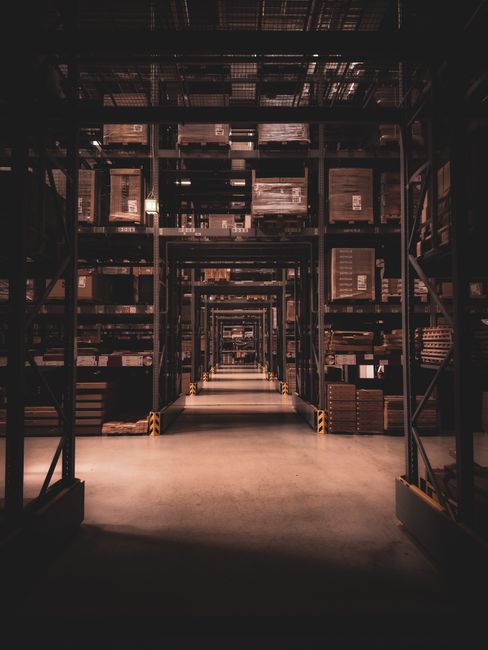 Dimly lit warehouse aisle in Berlin filled with large shelve