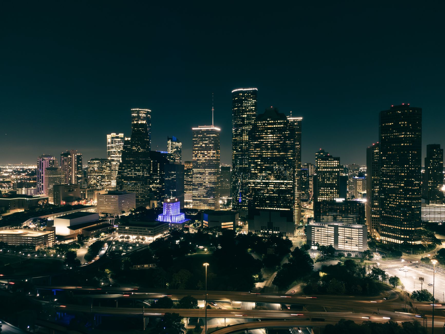Aerial view of a vibrant city skyline at night with illumina
