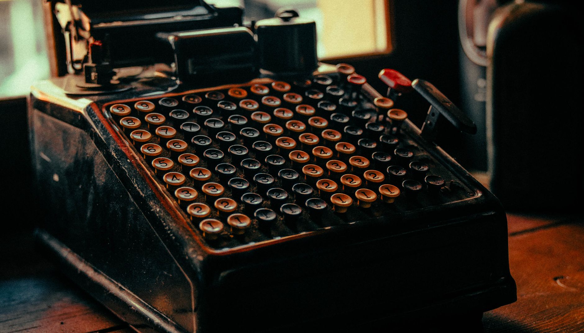 A close-up view of a retro adding machine with numeric keys
