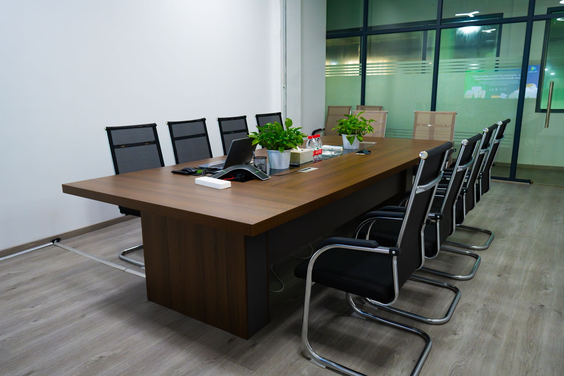 Spacious conference room featuring a long table, modern chai