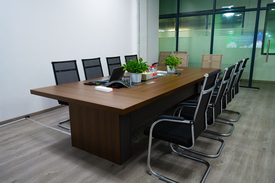 Spacious conference room featuring a long table, modern chai