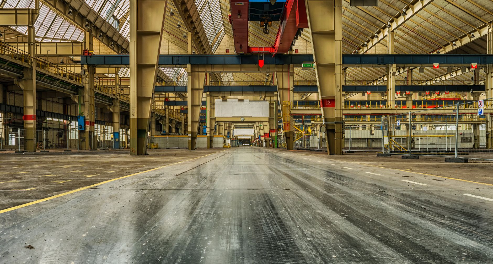 Wide view of an empty industrial warehouse with visible cran