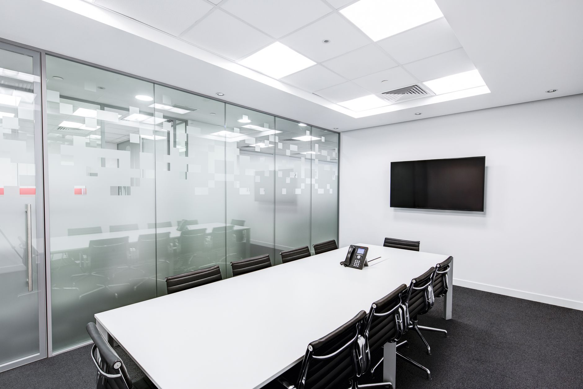 Sleek, minimalist conference room with glass walls, long tab