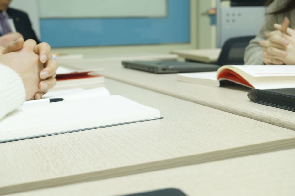 Close-up of a professional meeting setup with hands, laptops