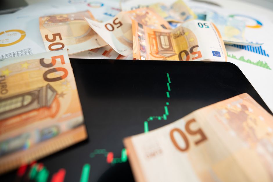 Close-up of 50 euro banknotes with a digital stock market ch