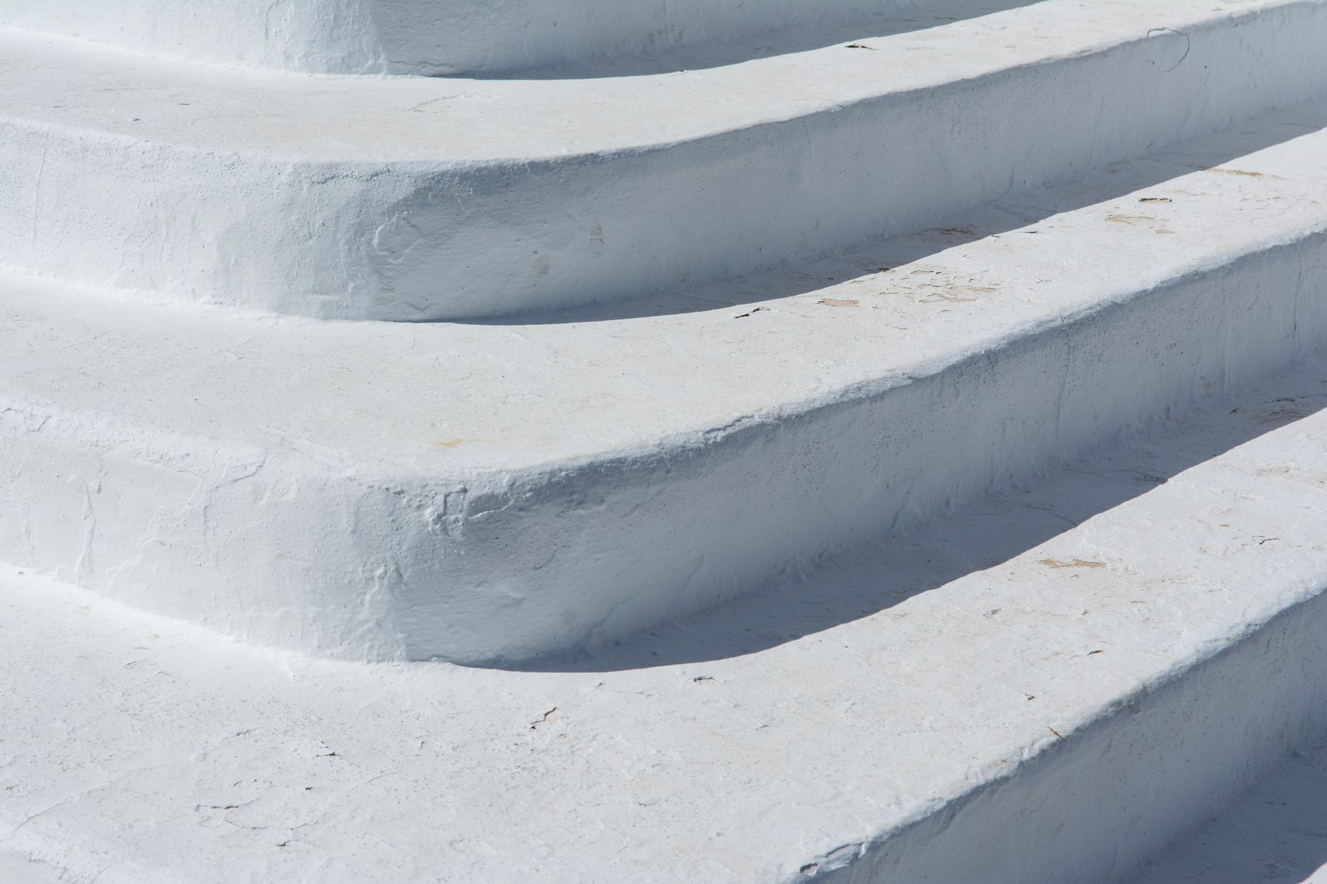 Close-up of textured white concrete steps in bright sunlight