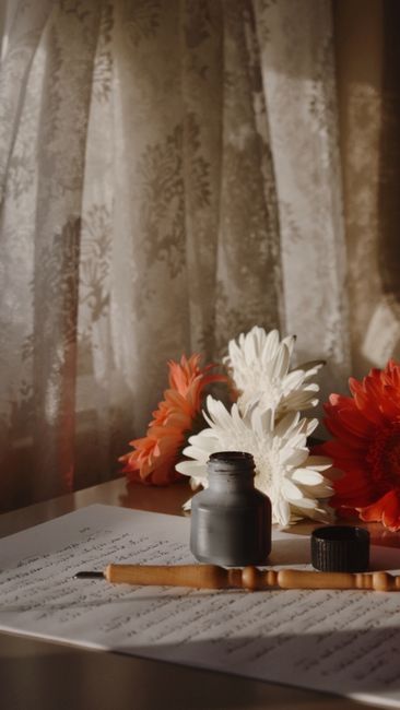 Warm still life featuring ink bottle and flowers with elegan