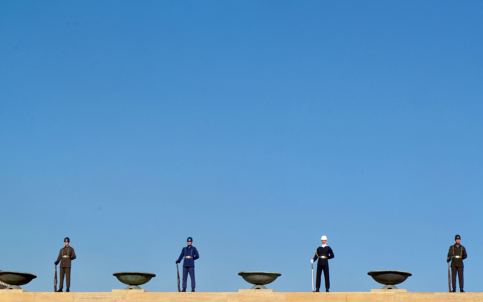 Uniformed guards standing at Anıtkabir in Ankara under a cle