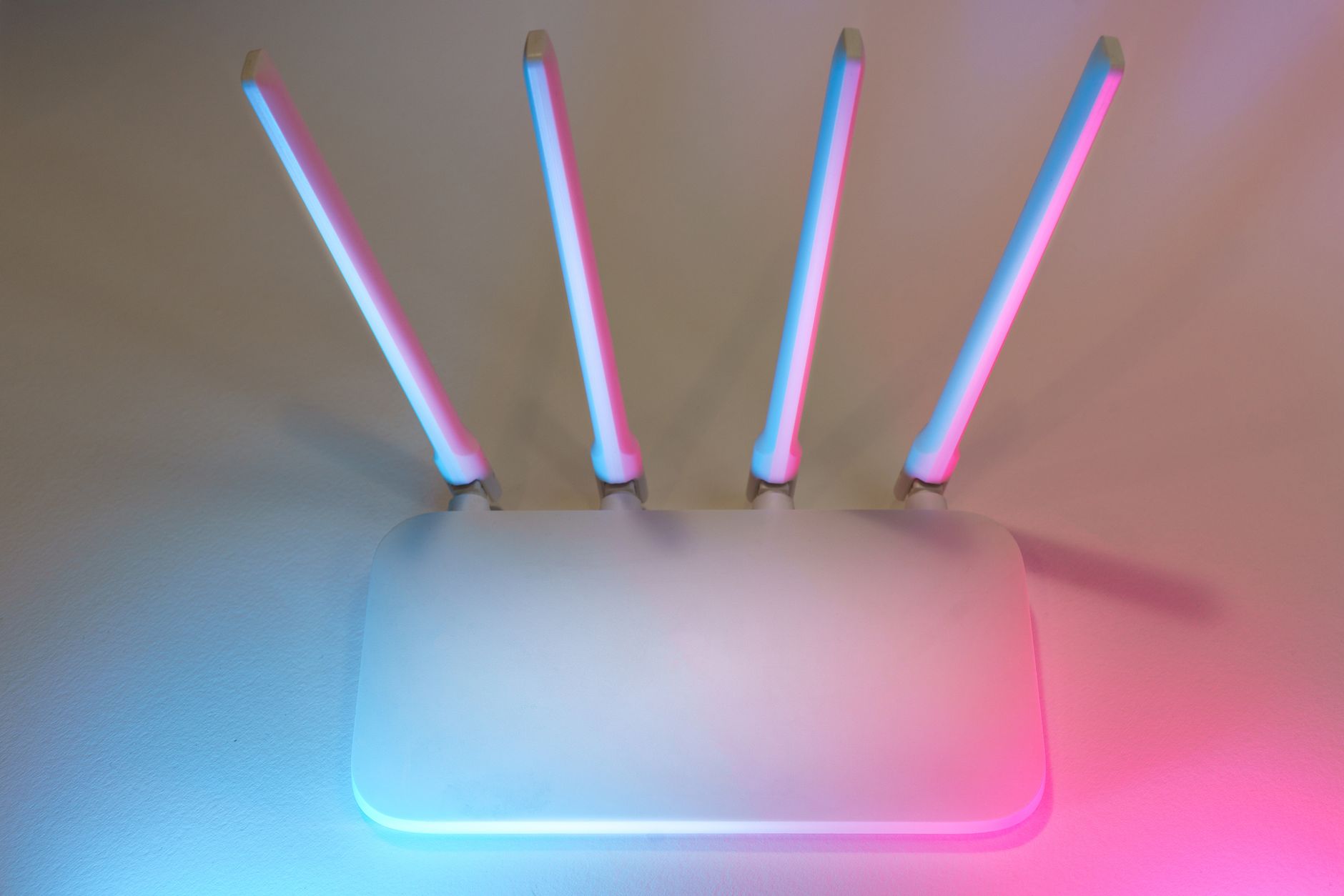 Sleek white wireless router with four antennas emitting soft