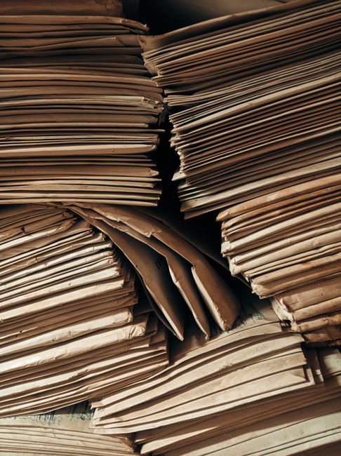 Piles of aged brown paper envelopes stacked closely, highlig