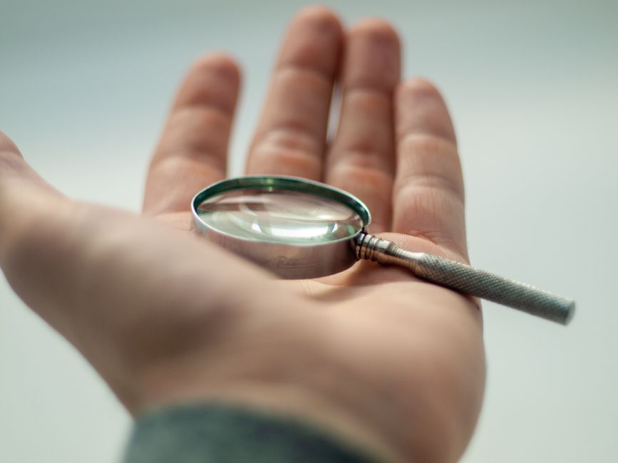 A detailed close-up of a hand holding a magnifying glass, sh