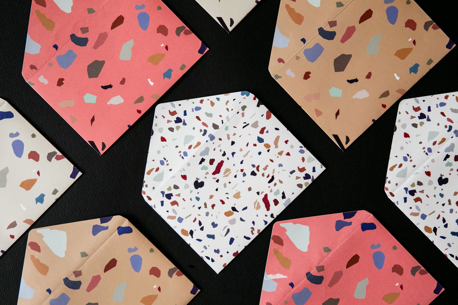 Top view of vibrant terrazzo patterned envelopes arranged on