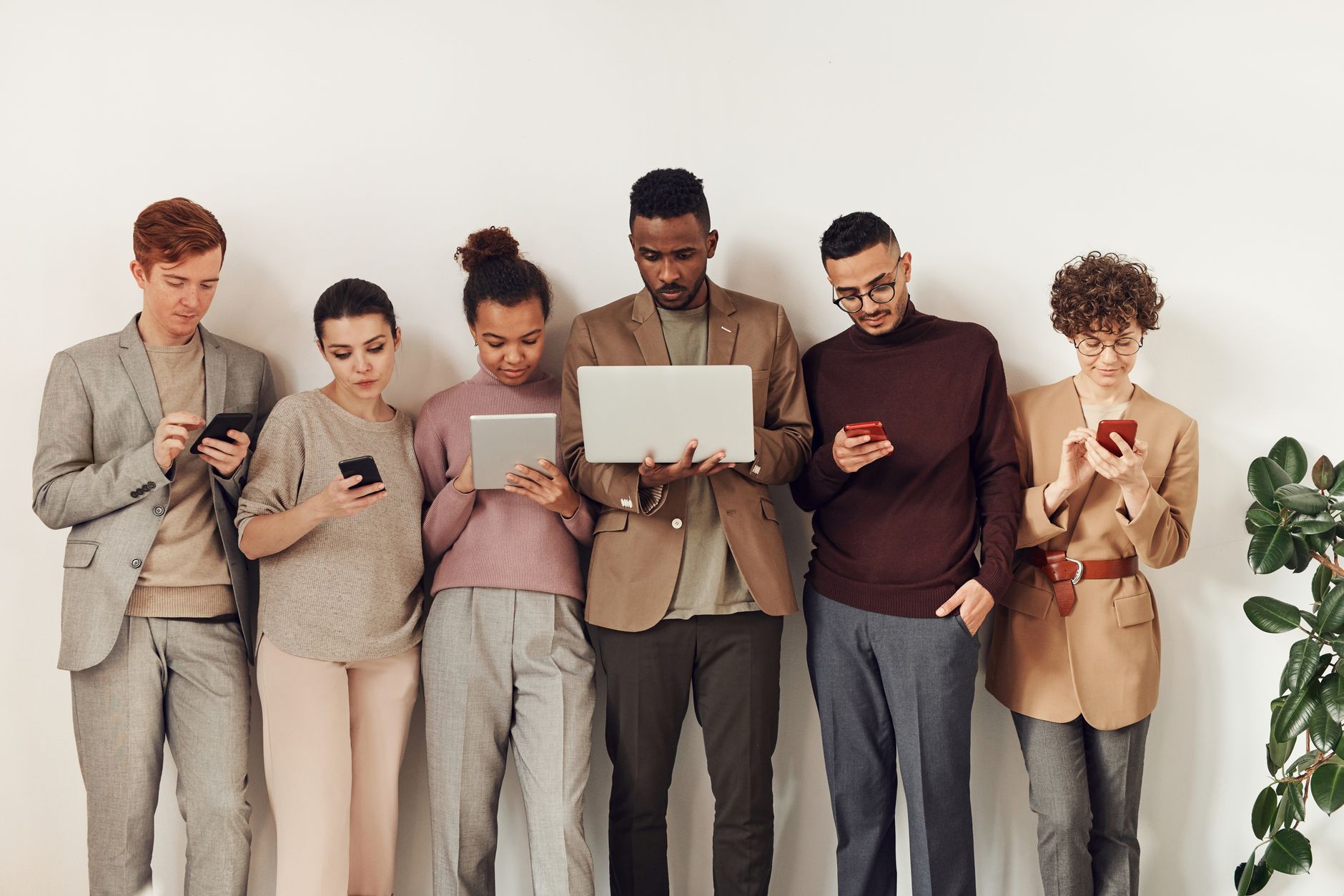 A diverse group of adults interacting with various devices i