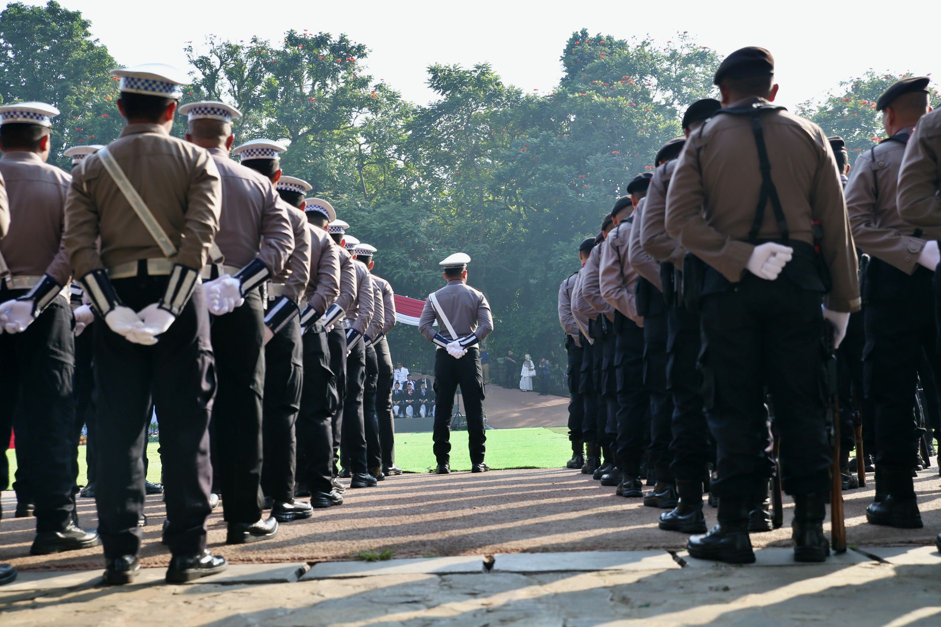 A group of police officers stands in formation outdoors, obs