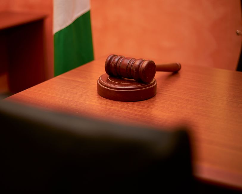 A close-up of a gavel on a courtroom desk representing law a