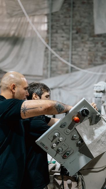 Two factory workers operate machinery with precision in an i