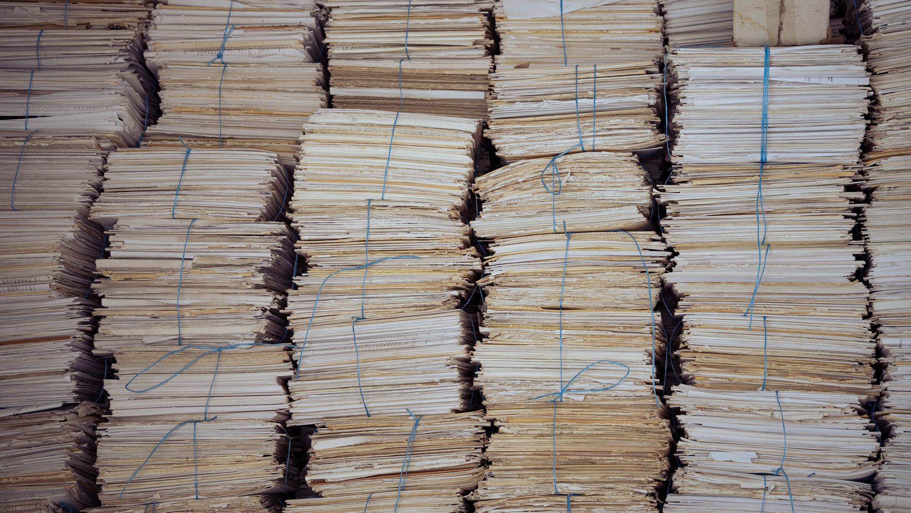 High stacks of organized, bound paper bundles create a struc