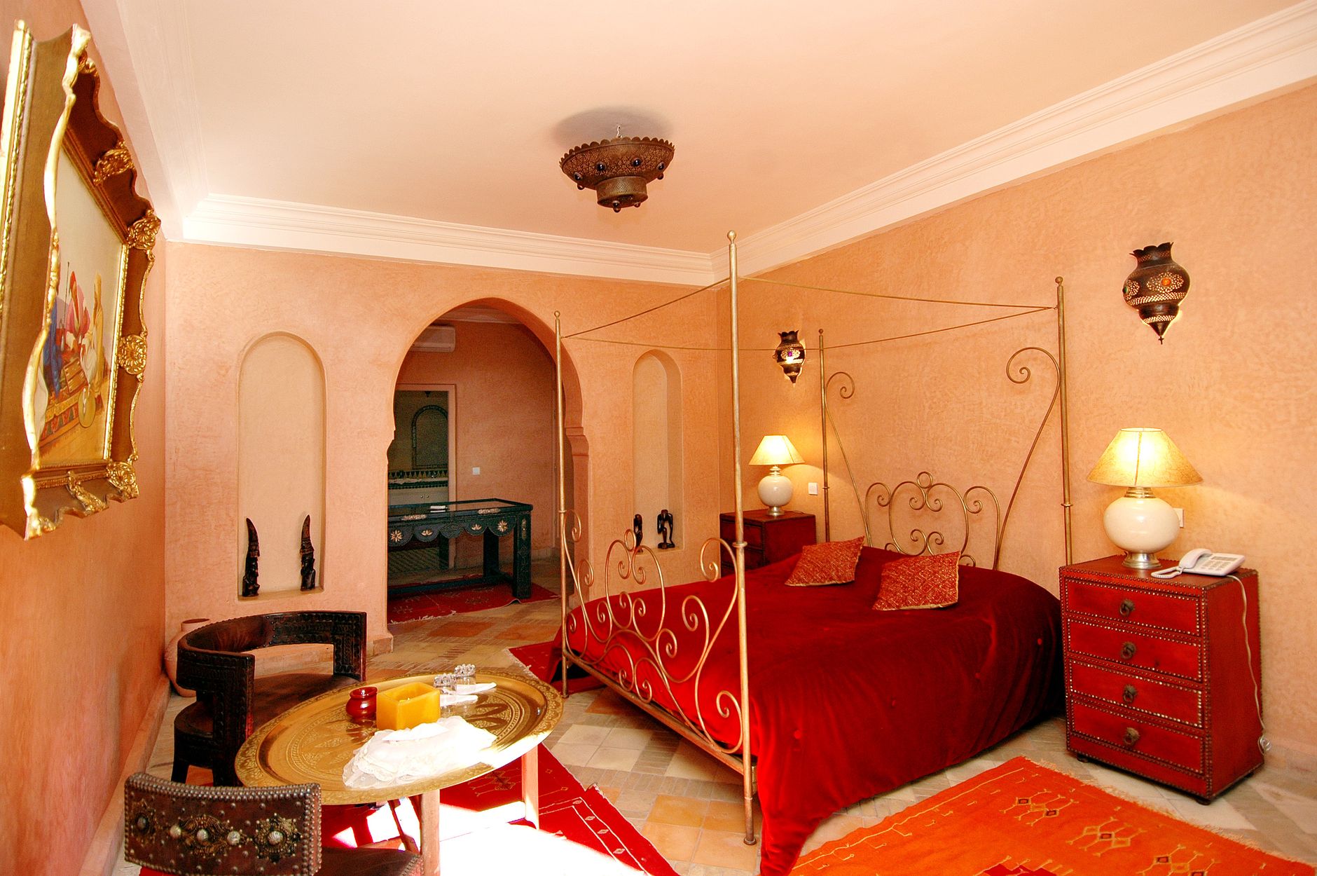 Luxurious Moroccan-themed bedroom featuring a red canopy bed