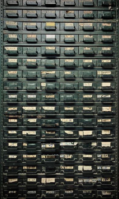 A vintage metal cabinet with labeled drawers, ideal for indu