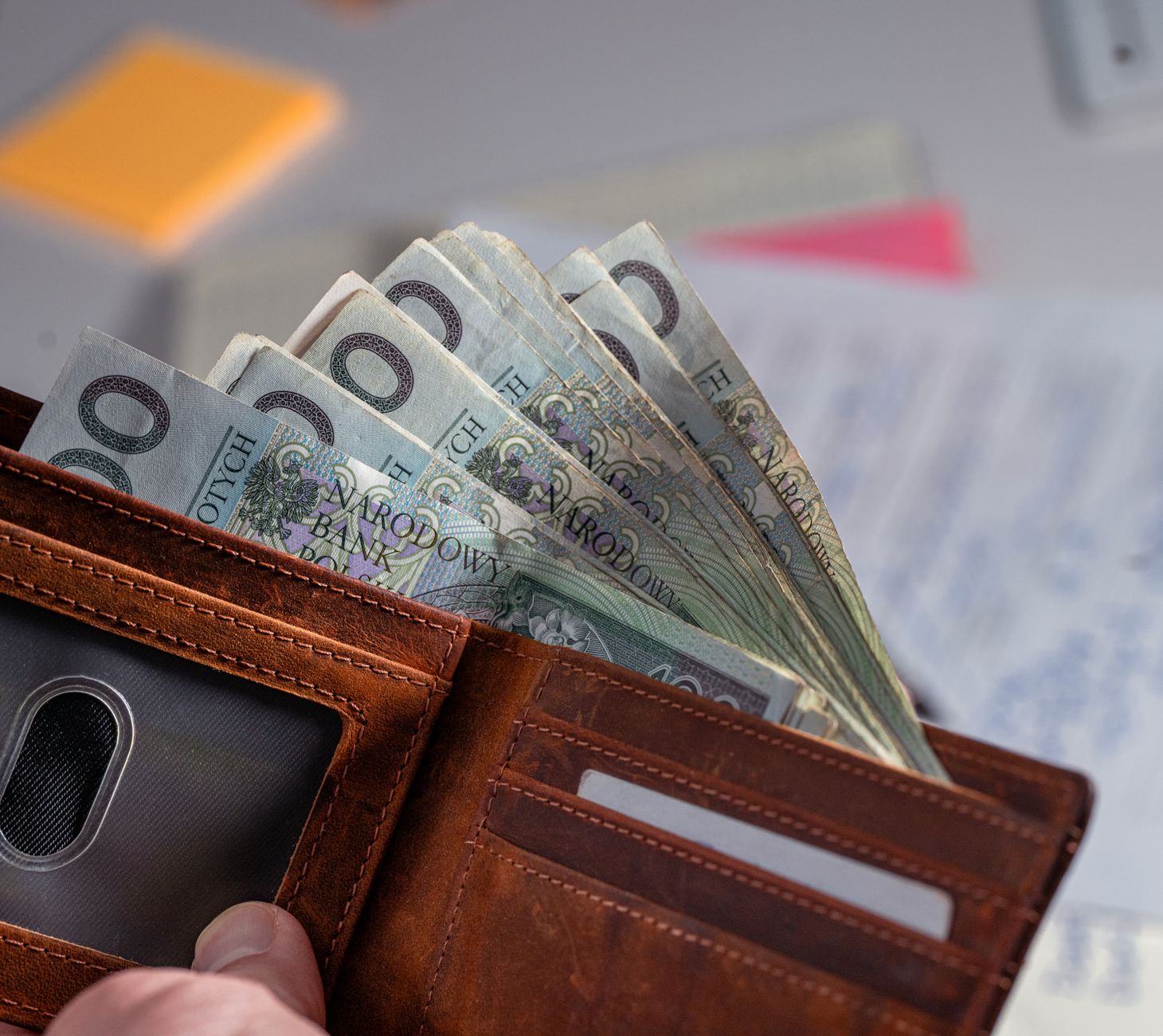 Brown leather wallet containing Polish zloty banknotes on cl