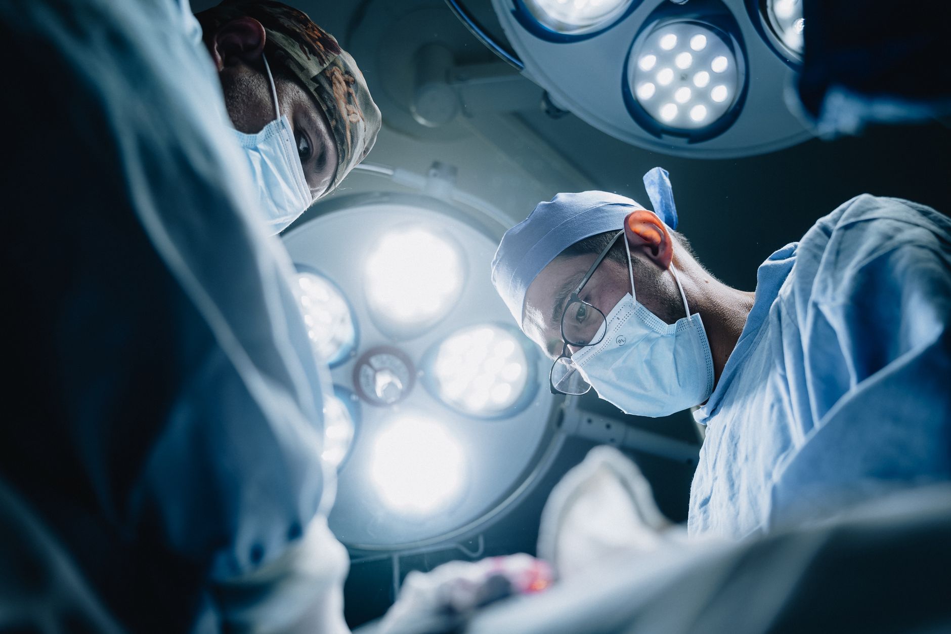 Surgeons in action under bright lights during a medical proc