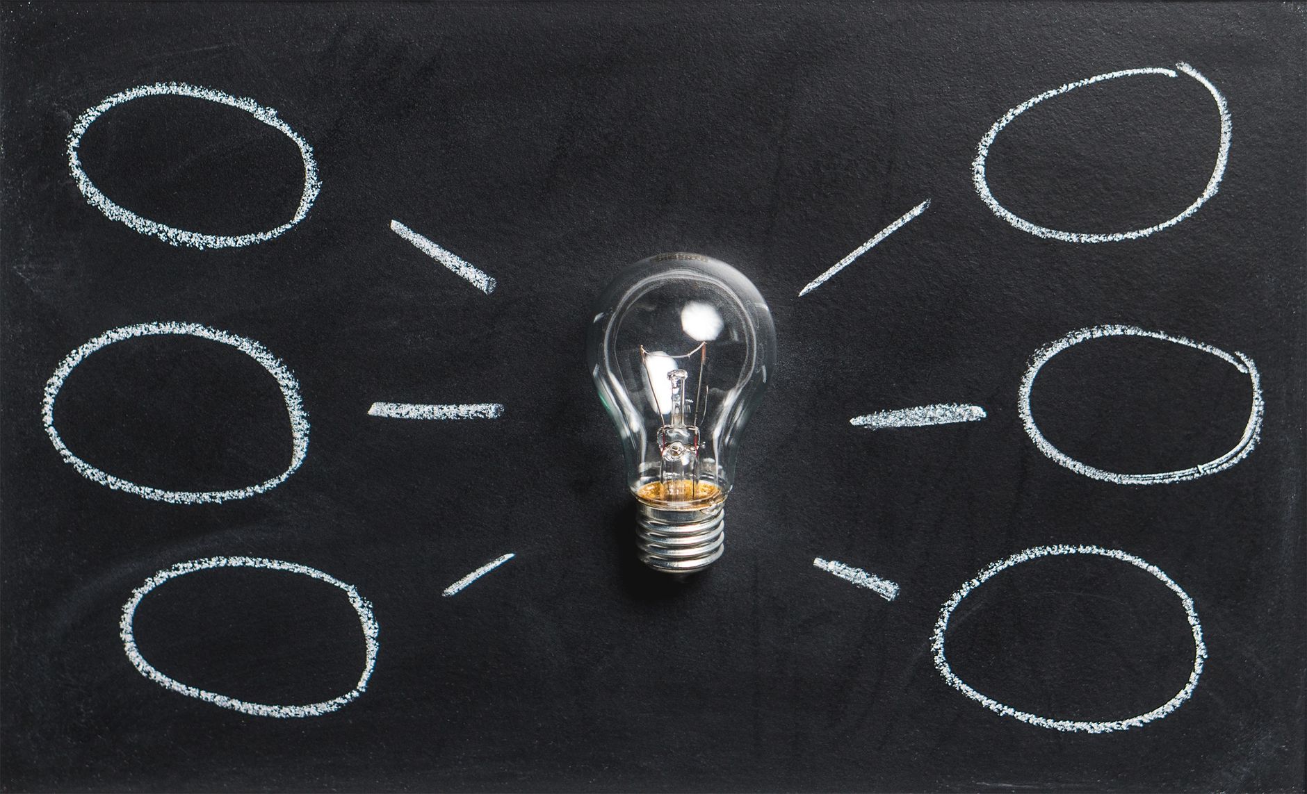 A lightbulb on a chalkboard symbolizes creativity, innovatio