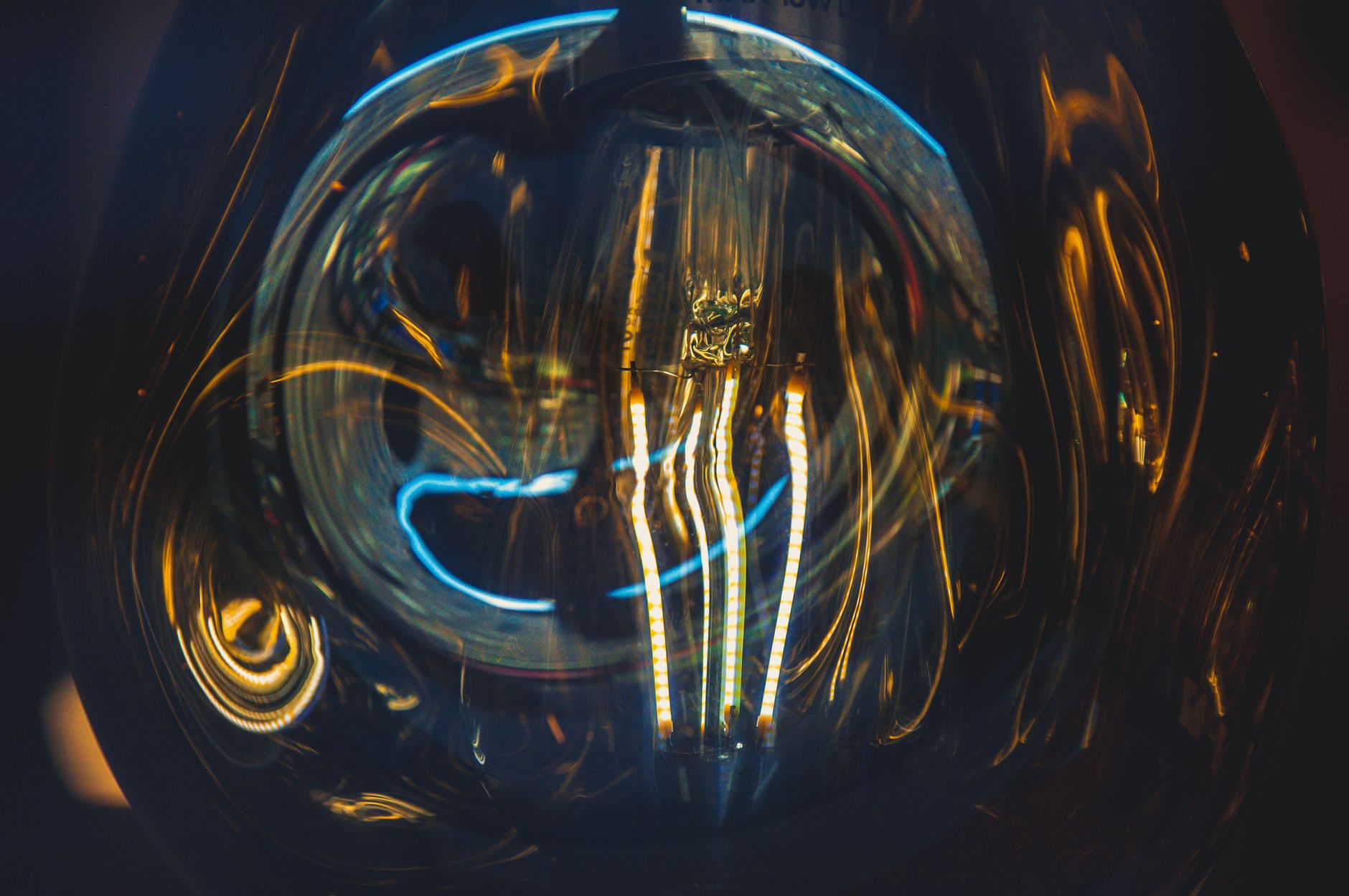 Dramatic close-up shot of a glowing light bulb filament with